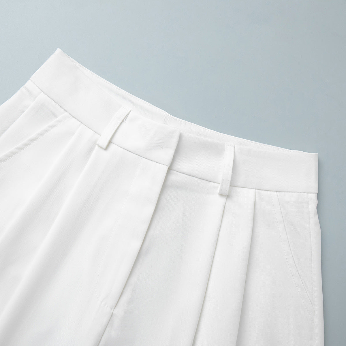 High-Waist Pleated Bermuda Shorts in White — close-up of waistband and pleats