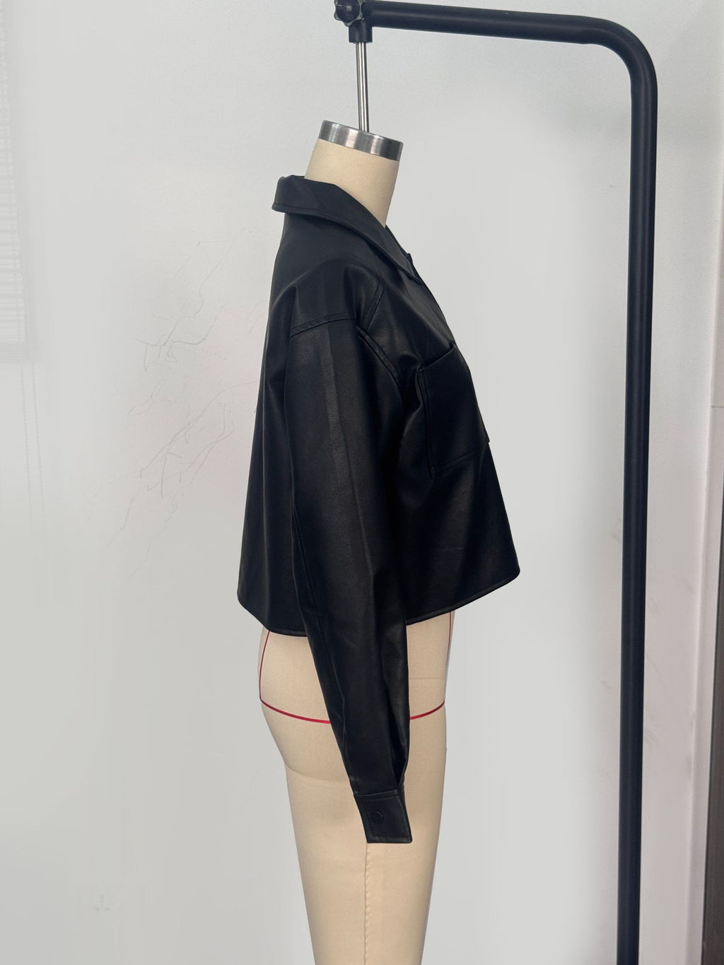 Cropped Faux Leather Shirt Jacket with Patch Pockets in Black — side view on a dress form