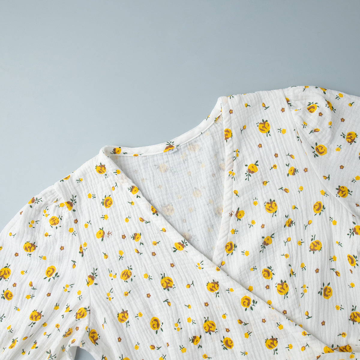 Cotton Floral Puff-Sleeve Wrap Midi Dress in Yellow Floral — close-up of the V neckline
