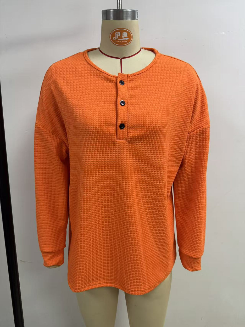 Waffle-Knit Henley Long-Sleeve Top in Orange — front view on a dress form