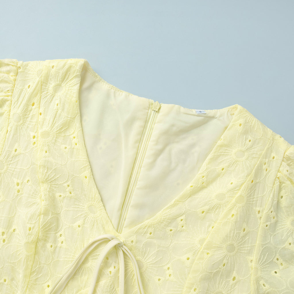 Yellow Eyelet Puff-Sleeve Mini Dress in Pale Yellow — close-up of the front tie