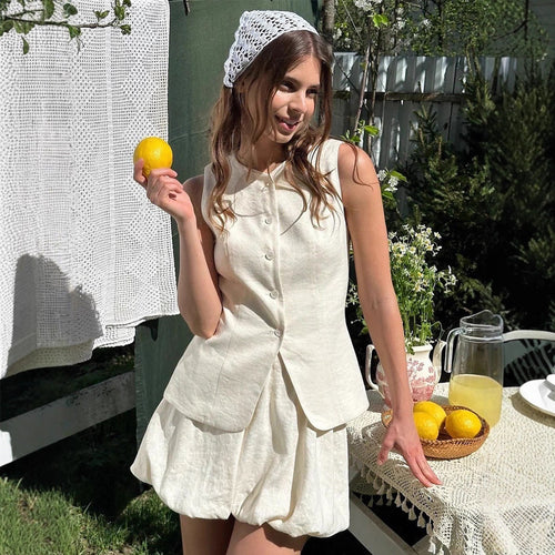 Cotton Peplum Vest & Bubble Mini Skirt Set in White — front view on model in garden