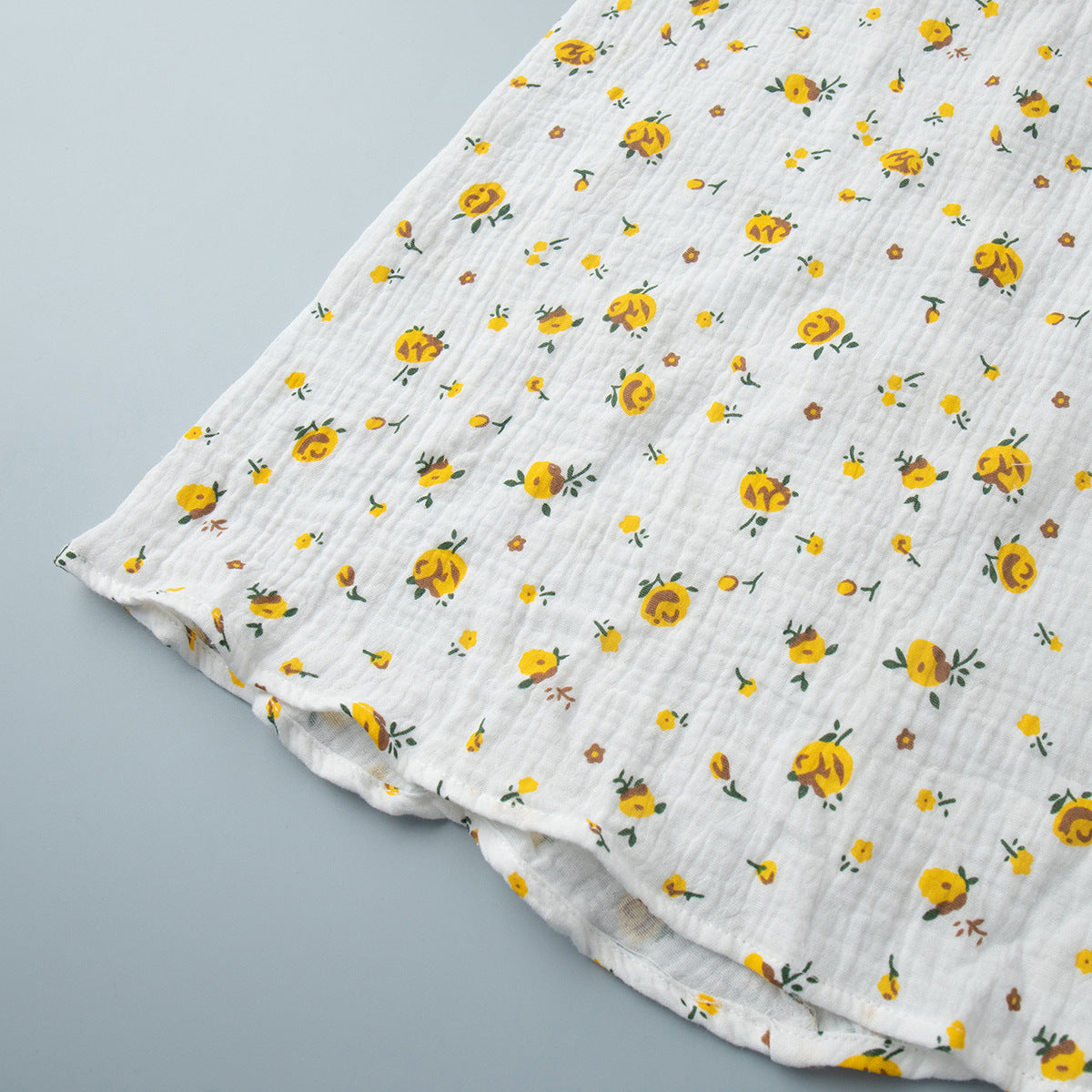 Cotton Floral Puff-Sleeve Wrap Midi Dress in Yellow Floral — close-up of the hem