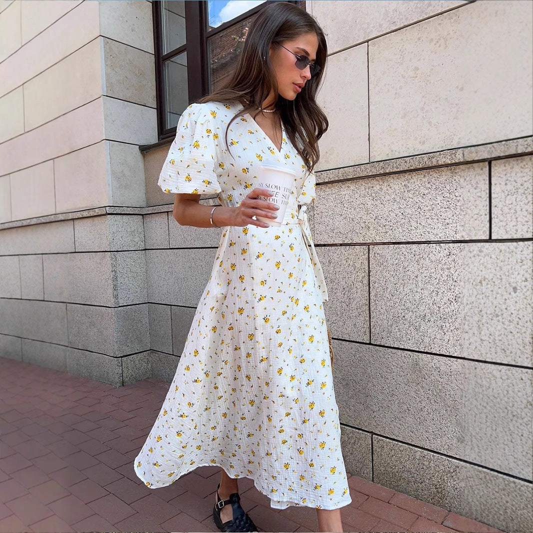 Cotton Puff-Sleeve Wrap Midi Dress in Blue Floral — outdoor view by stone wall