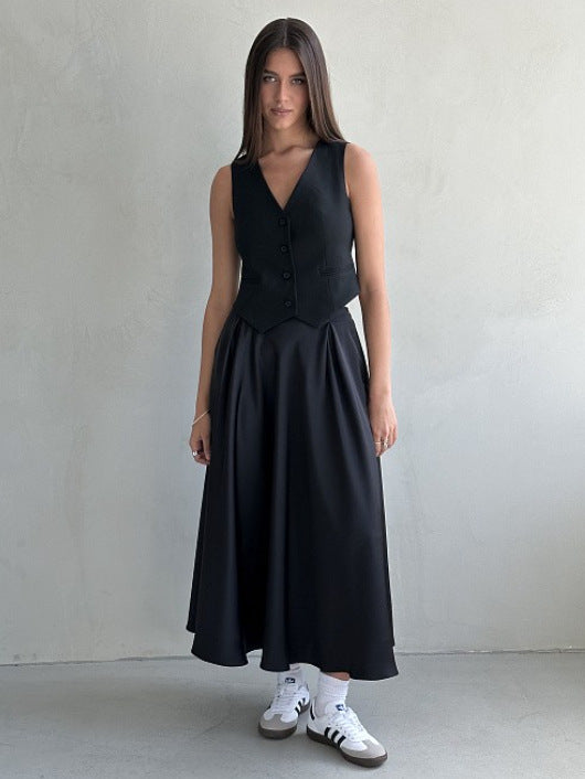 Satin A-Line Midi Skirt with Elastic Waist in Black — front view on model with a black vest