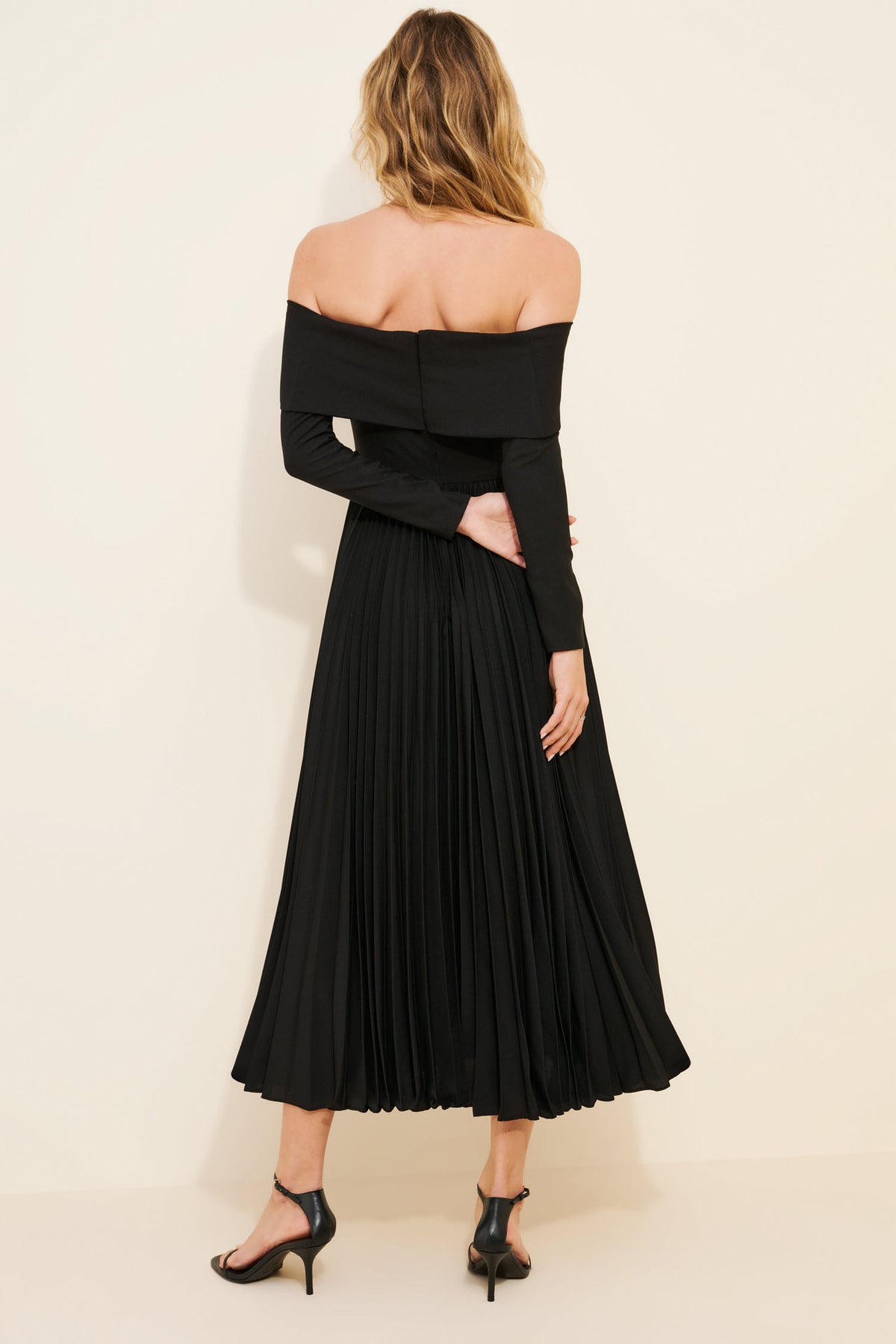 Off-the-Shoulder Long Sleeve Pleated Midi Dress in Black — back view on model