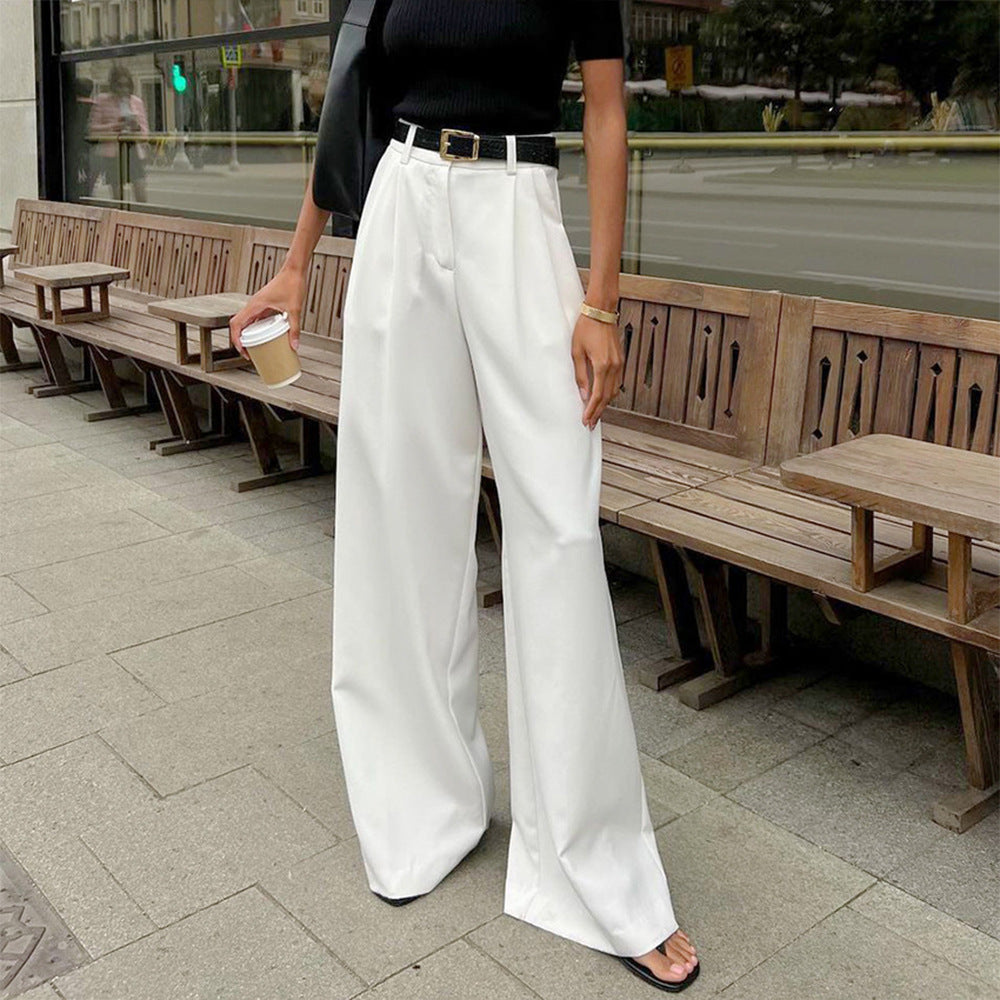 High-Waist Pleated Wide-Leg Trousers in White — on model, seated