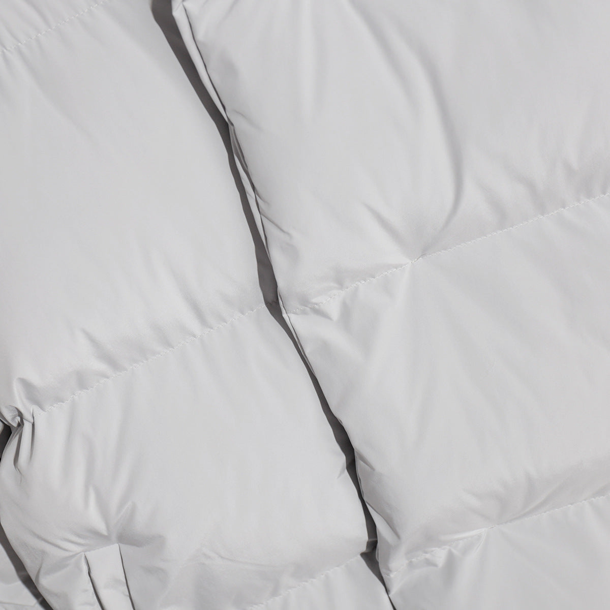 Matte Oversized Hooded Puffer Jacket in Light Gray — close-up of the quilting