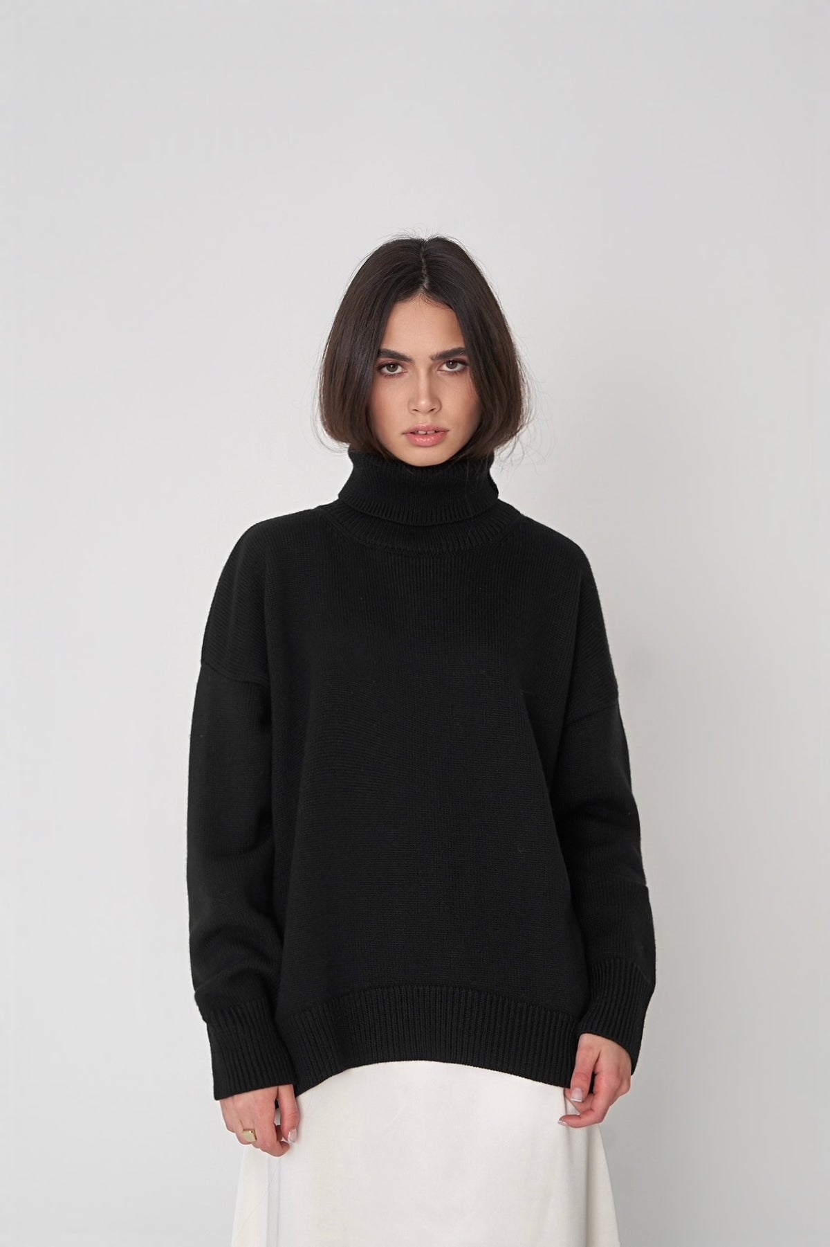 Oversized Knit Turtleneck Sweater in Black — front view on model