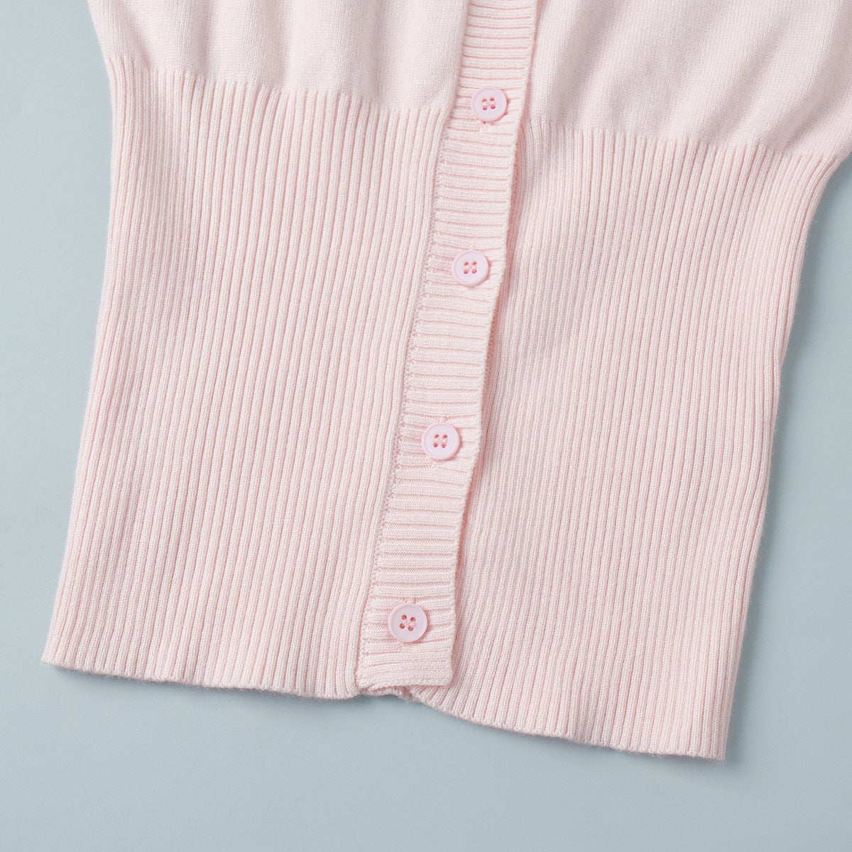 Fitted Cropped Ribbed Knit Cardigan in Blush Pink — close-up of button front and ribbed hem