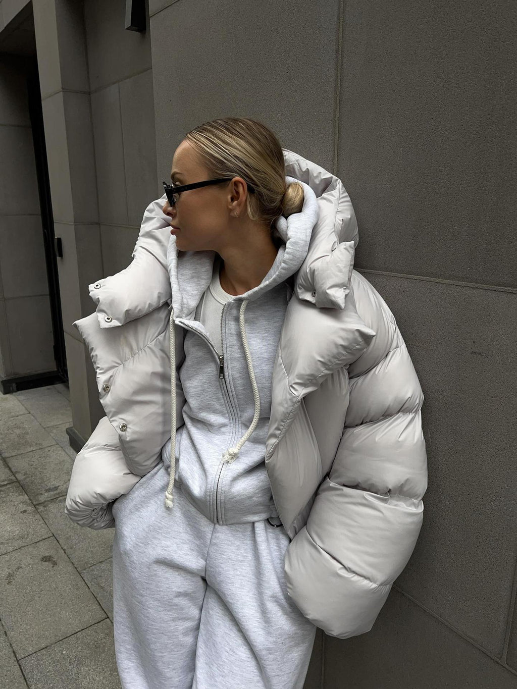 Cropped Hooded Puffer Jacket with Drawstring Hem in Light Gray — front view on model, worn over a hoodie