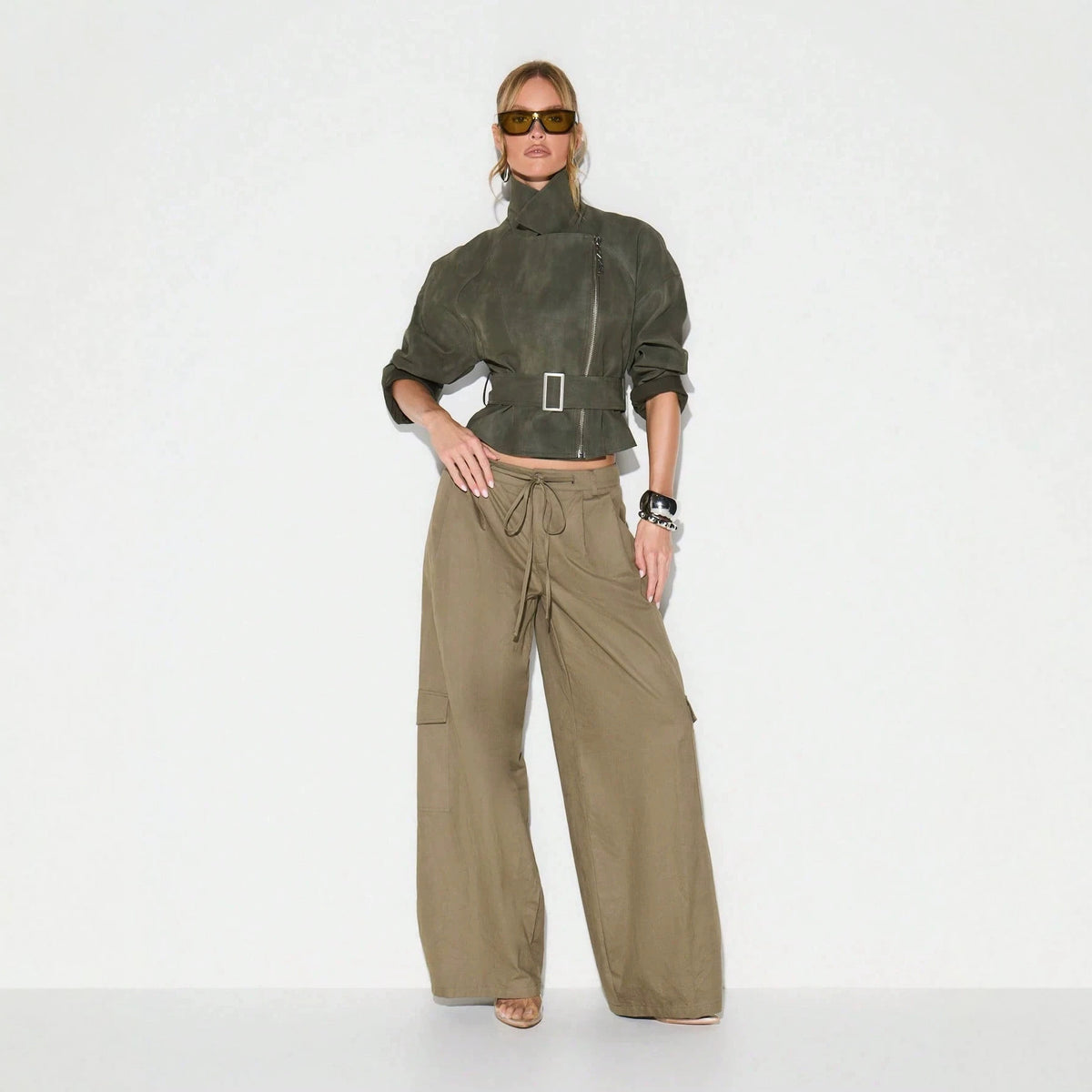 Belted Faux Suede Moto Jacket with Asymmetric Zip in Olive — full-length view on model with wide-leg trousers