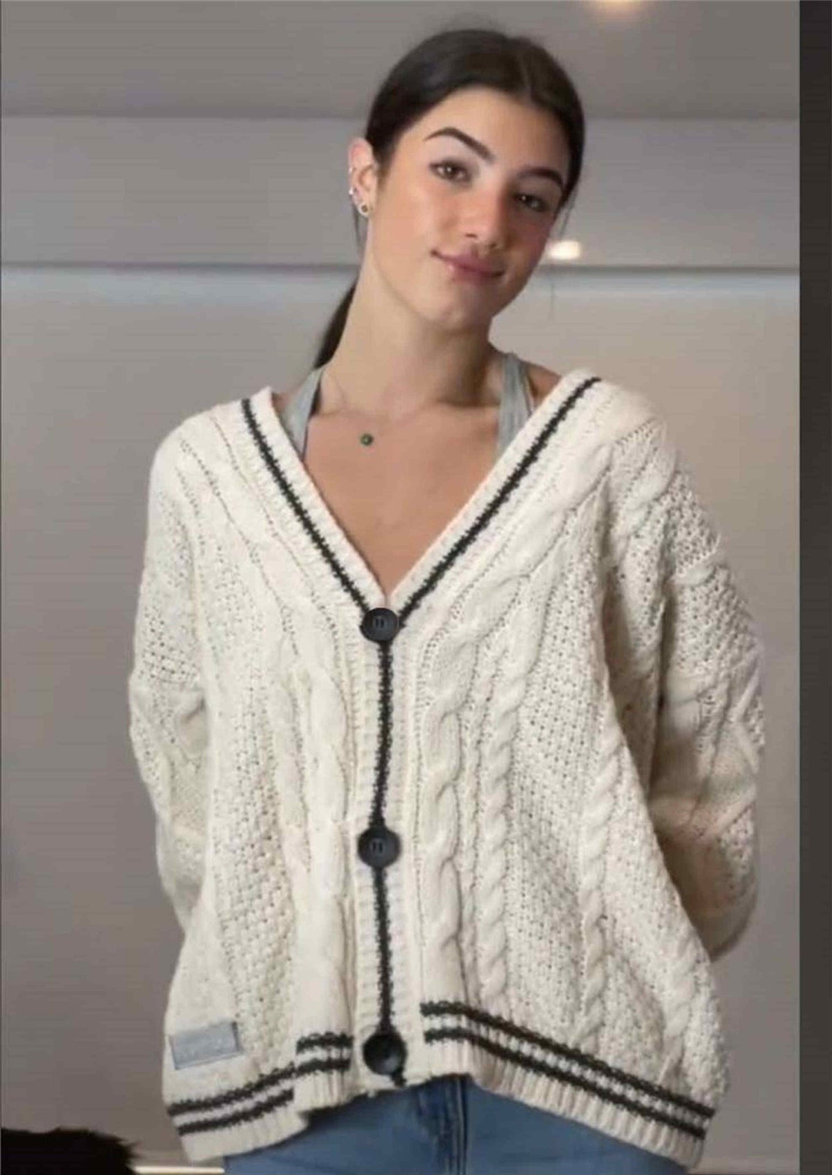 Star-Elbow Cable Knit Cardigan in Ivory with Black Trim — front view on model