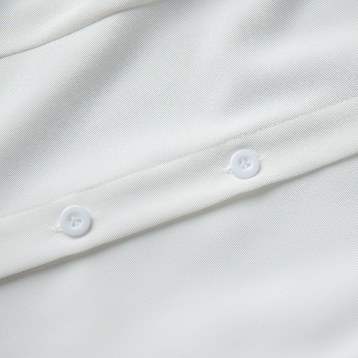 Sleeveless Button-Front Collared Maxi Dress in White — close-up of the buttons