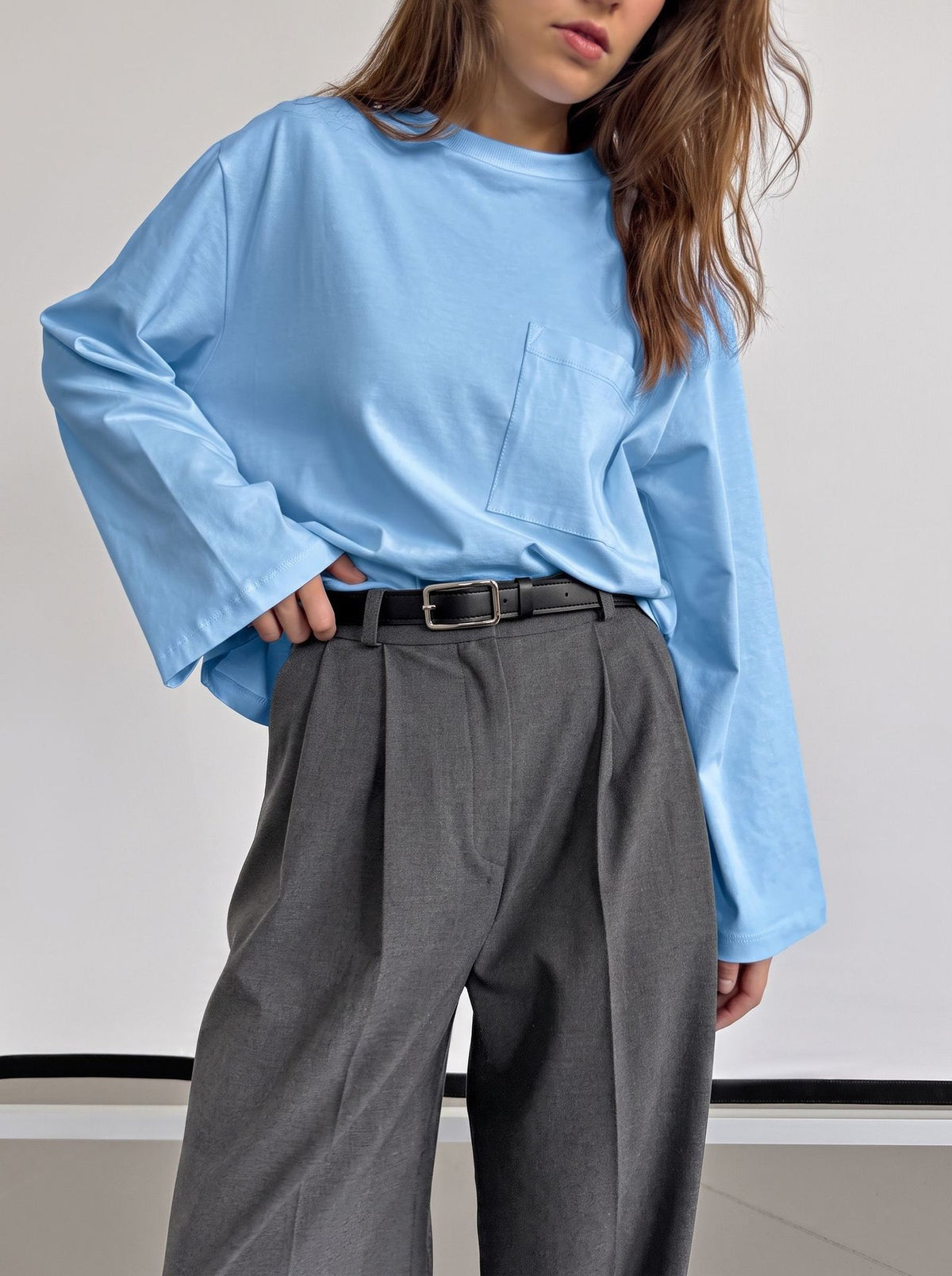 Relaxed Cotton Long-Sleeve Pocket Tee in Sky Blue — front view on model with gray trousers