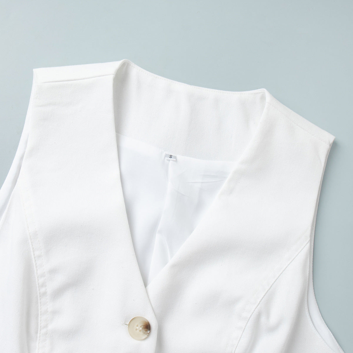 Linen-Blend Vest & Pleated Shorts Set in White — close-up of the V-neck and buttons
