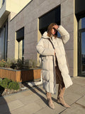 Long Hooded Puffer Coat with Tie Belt in Ivory — front view on model or garment