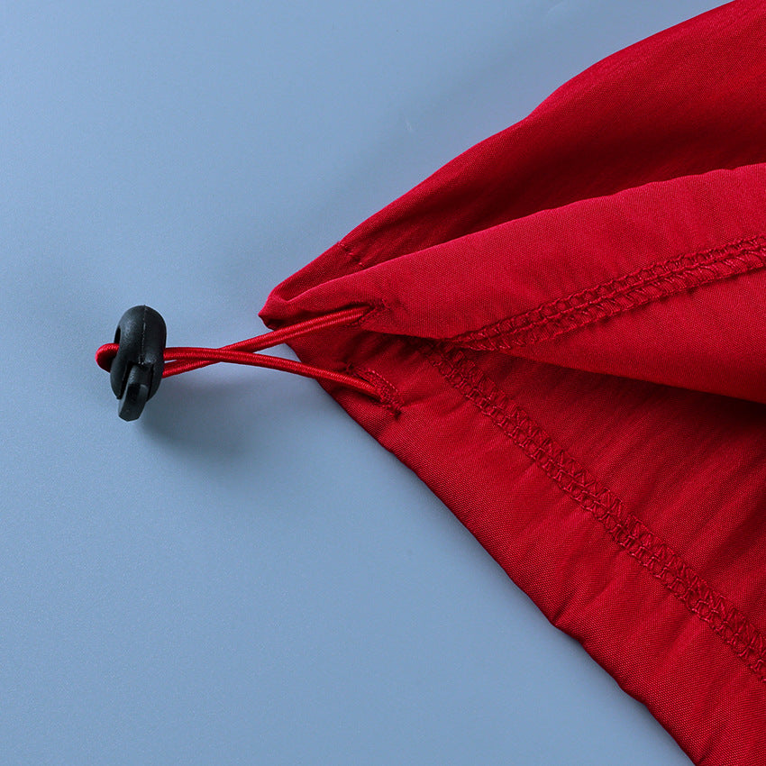 Button-Placket Stand-Collar Jacket with Elastic Cuffs in Red — close-up of the drawcord toggle