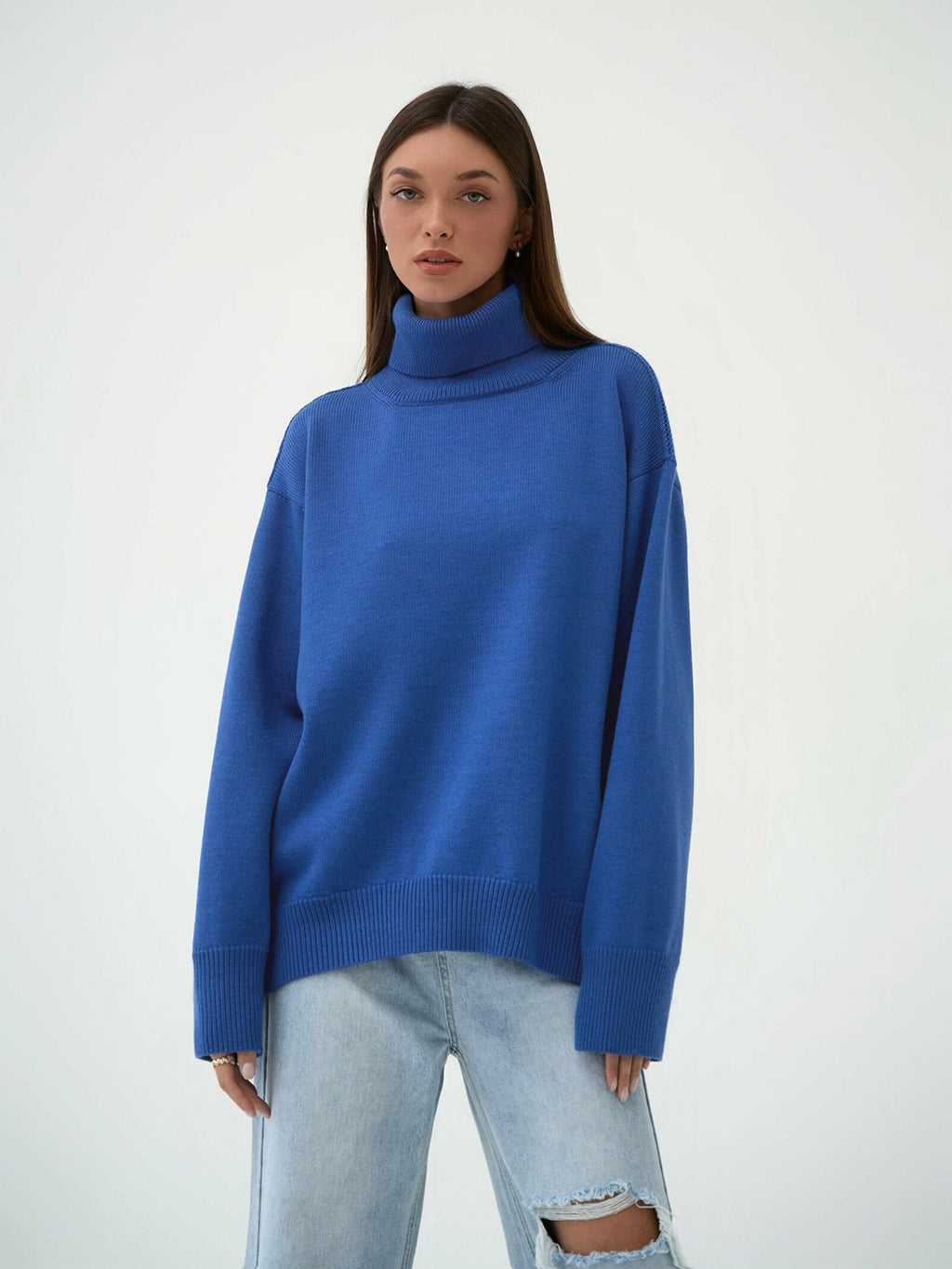 Oversized Knit Turtleneck Sweater in Cobalt Blue — front view with jeans