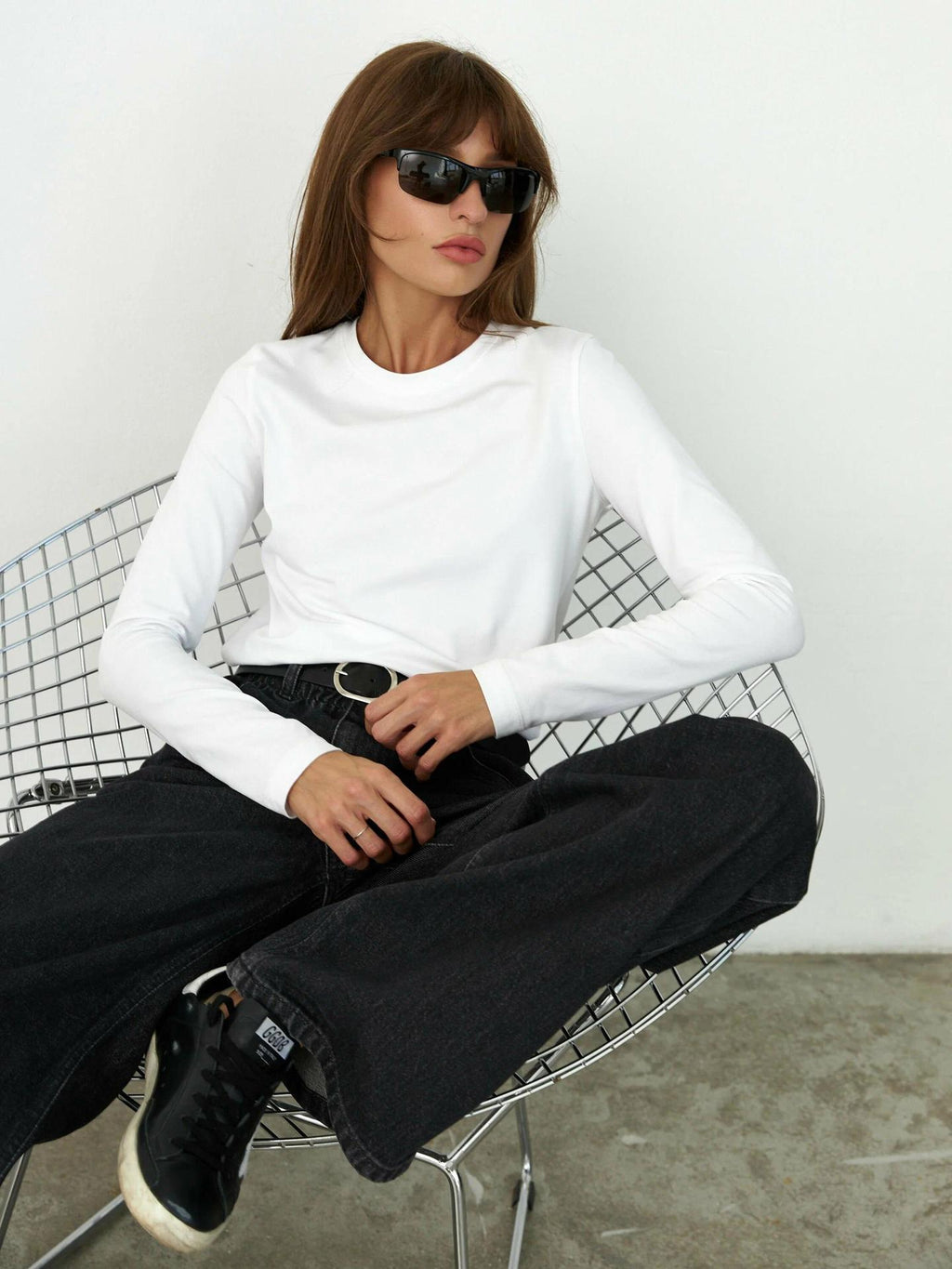 Everyday Cotton Crew Neck Long Sleeve Tee in White — seated, tucked into jeans