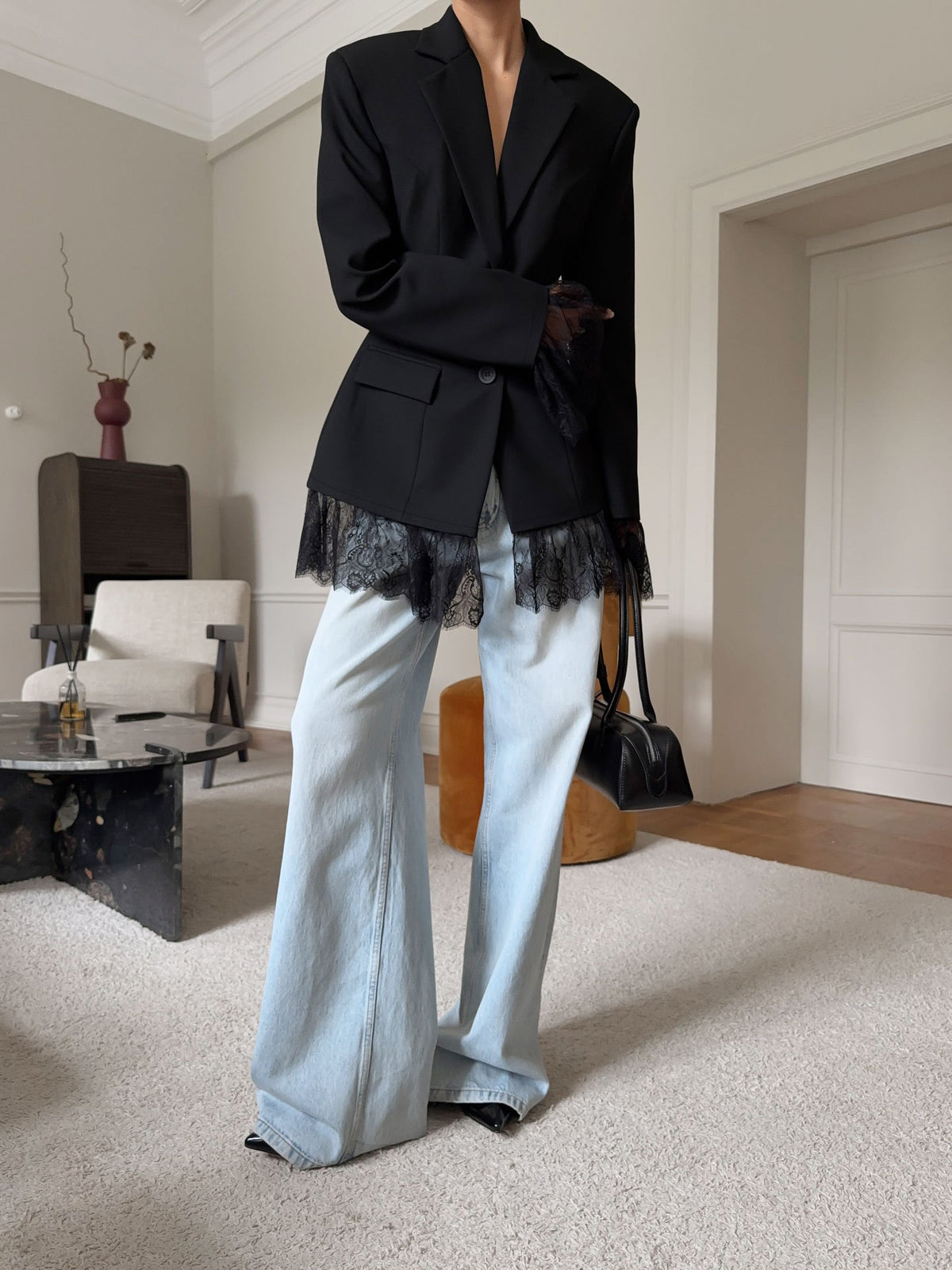Fitted Blazer with Lace-Trimmed Hem and Cuffs in Black — side view on model