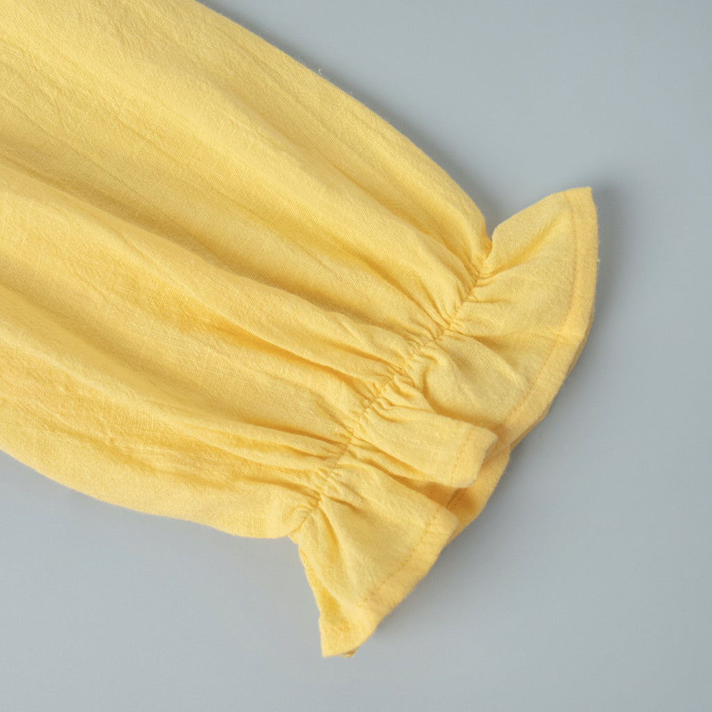 Tie-Front Puff-Sleeve Top & Maxi Skirt Set in Butter Yellow — close-up of the back neck slit