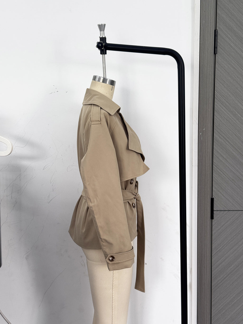 Cropped Double-Breasted Trench Jacket with Belt and Epaulettes in Khaki — side view on a dress form