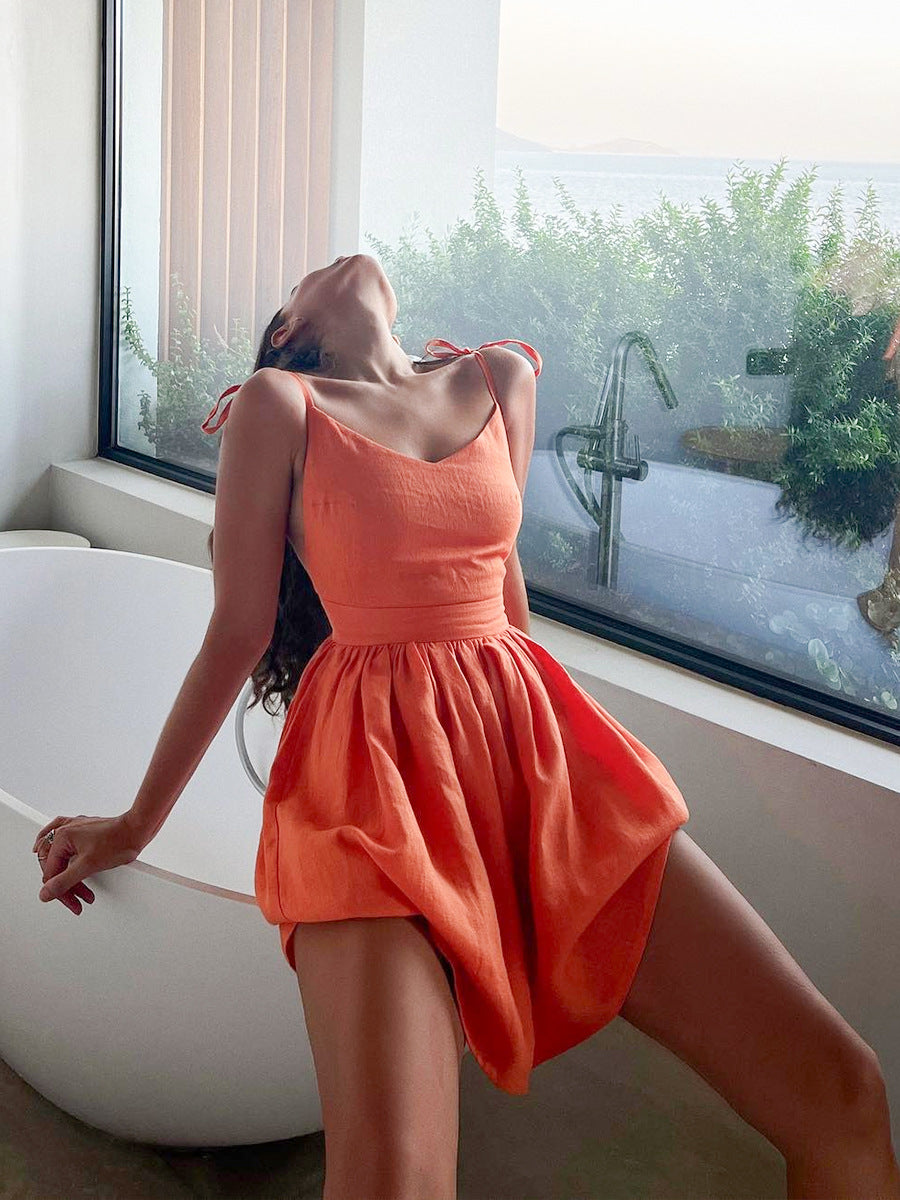 Tie-Shoulder Open-Back Cotton Mini Dress in Bright Orange — on model by window