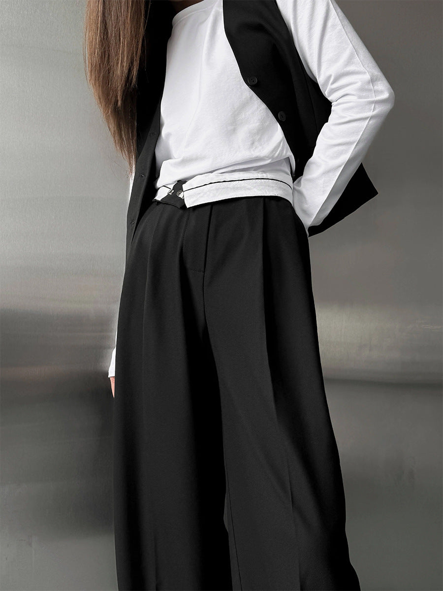 Pleated Wide-Leg Trousers in Black — close-up on model