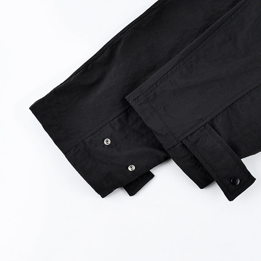 Oversized Stand-Collar Nylon Jacket with Drawcord Hem in Black — close-up of the snap-tab cuff