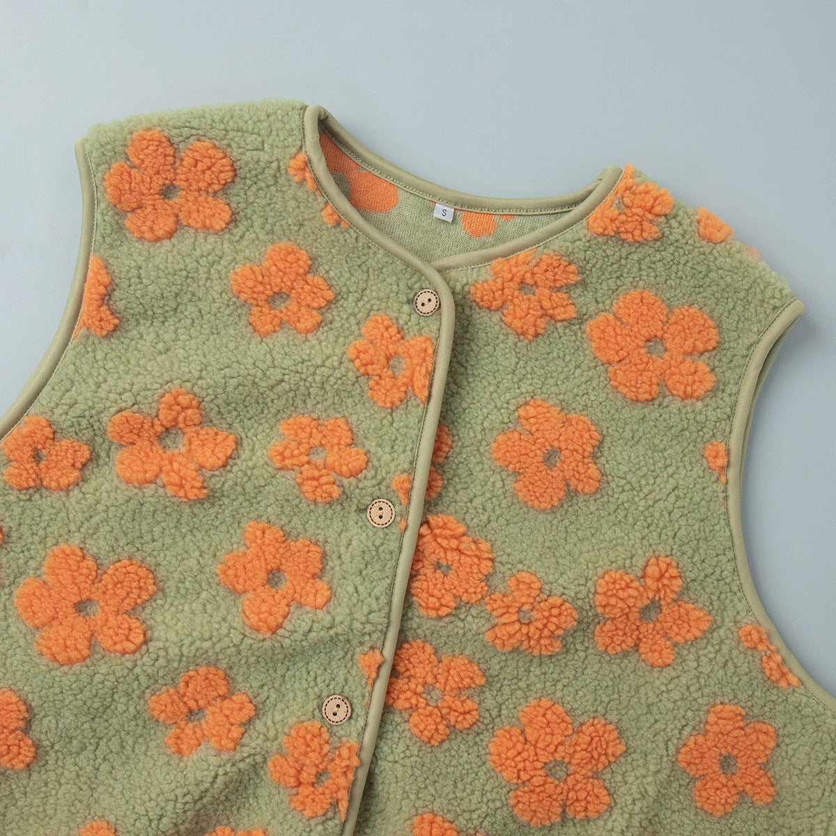 Floral Sherpa Fleece Button Vest with Pockets in Sage & Orange Floral — close-up of the neckline and buttons