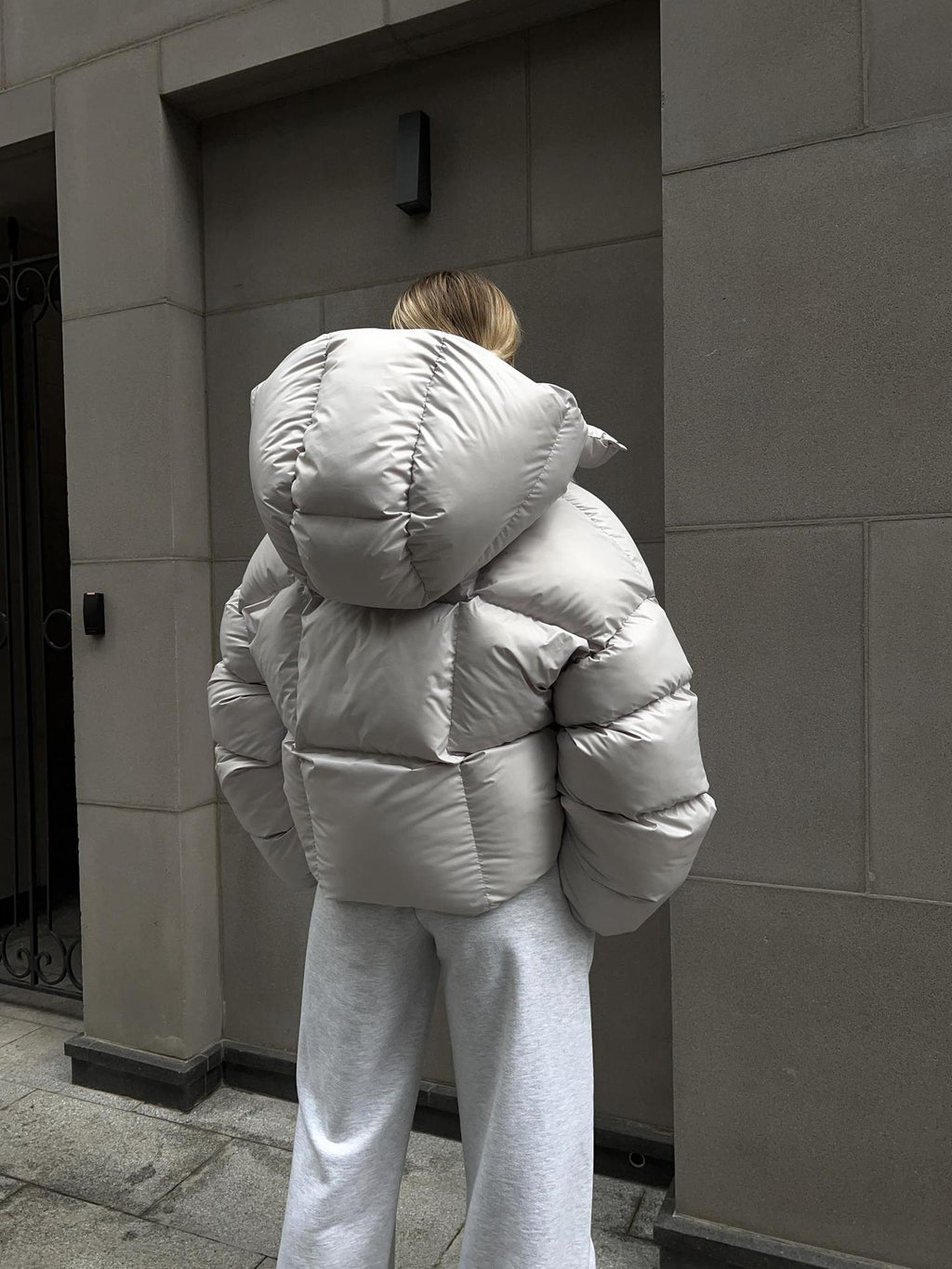 Cropped Hooded Puffer Jacket with Drawstring Hem in Light Gray — back view on model