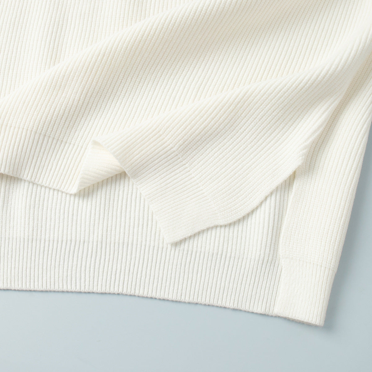 Half-Zip Polo Knit Sweater & Wide-Leg Pants Set in Ivory — close-up of the side slit