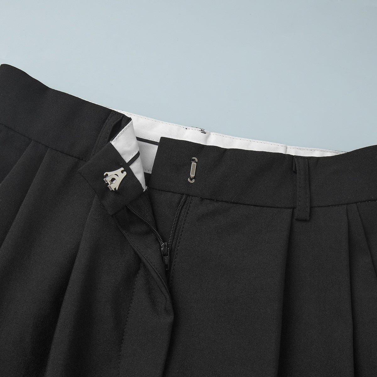 Pleated Wide-Leg Trousers in Black — close-up of zip fly and hook-and-bar