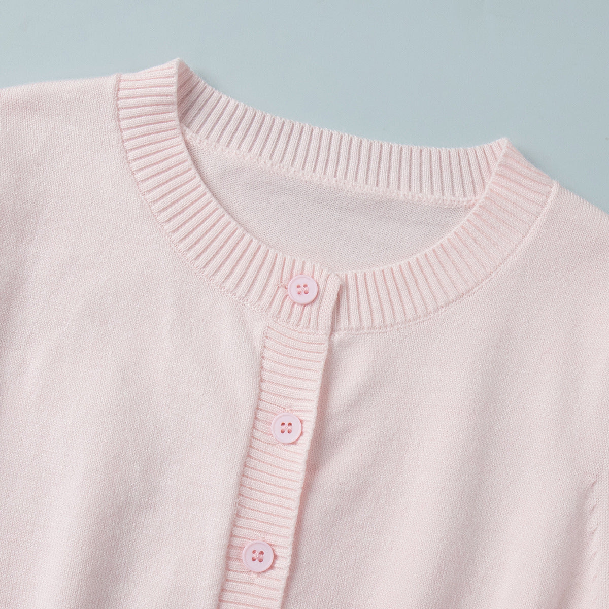 Fitted Cropped Ribbed Knit Cardigan in Blush Pink — close-up of crew neckline and rib knit