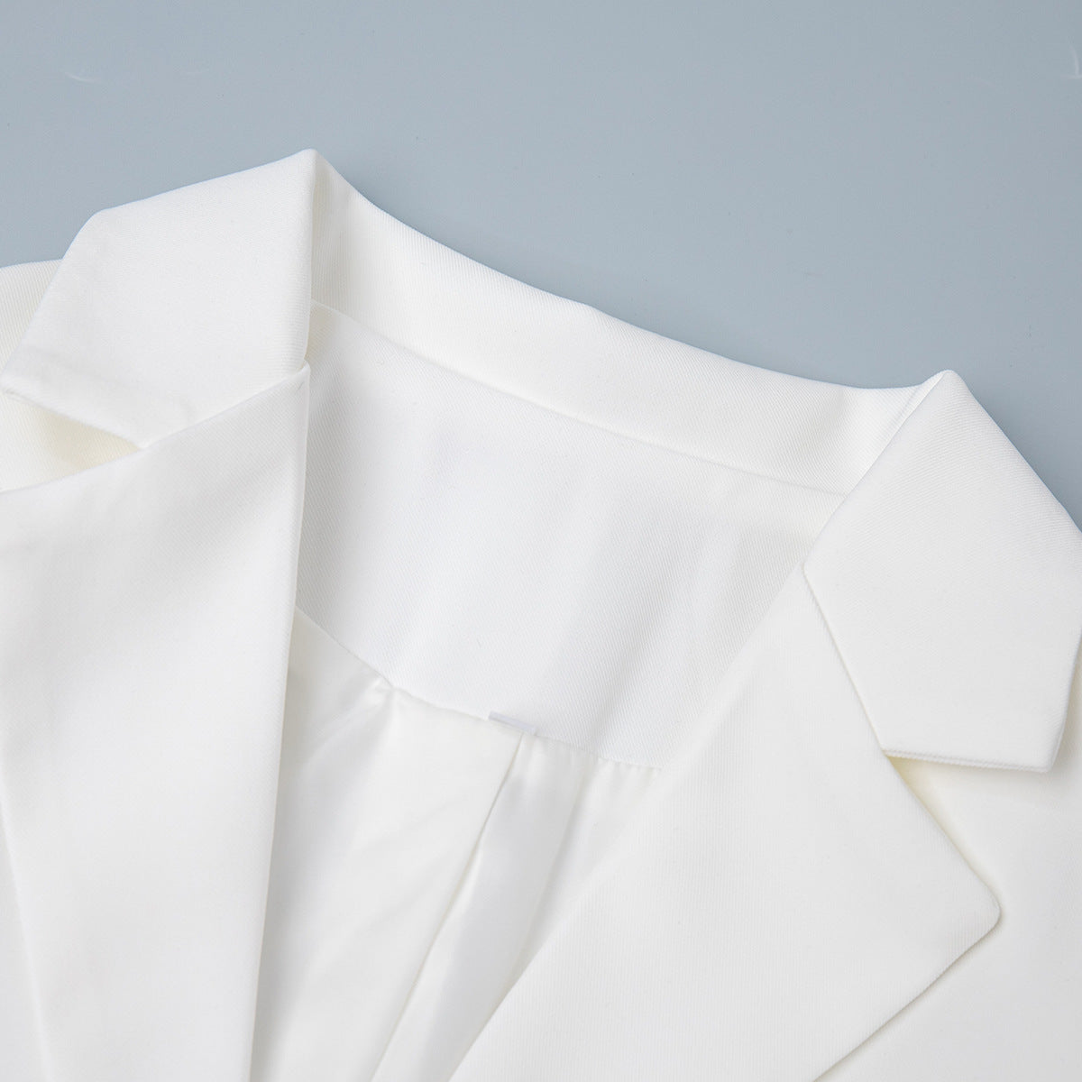 Tailored Two-Button Blazer with Cinched Waist in Ivory — close-up of the notch lapel