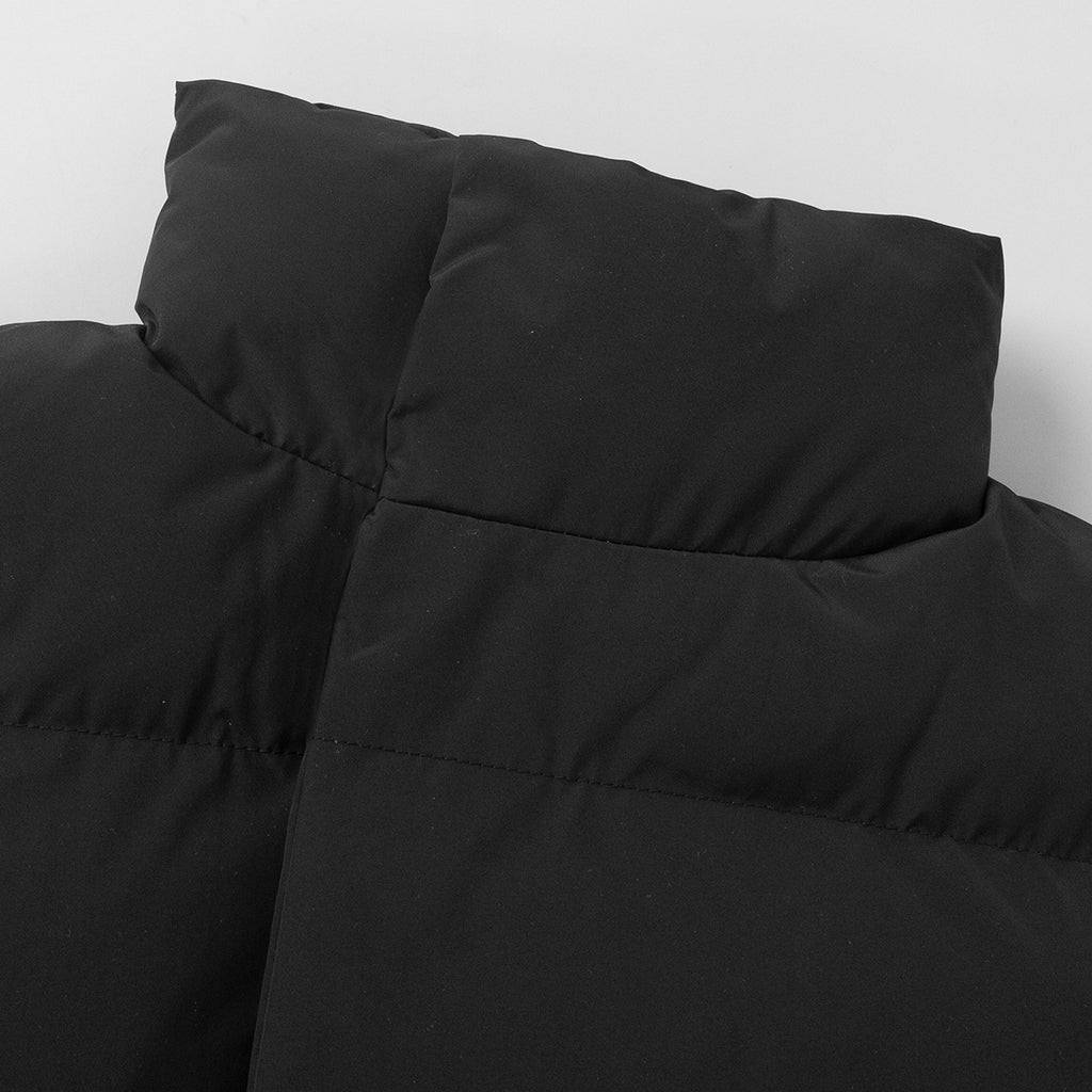 Longline Puffer Vest with High Stand Collar in Black — close-up of the quilting