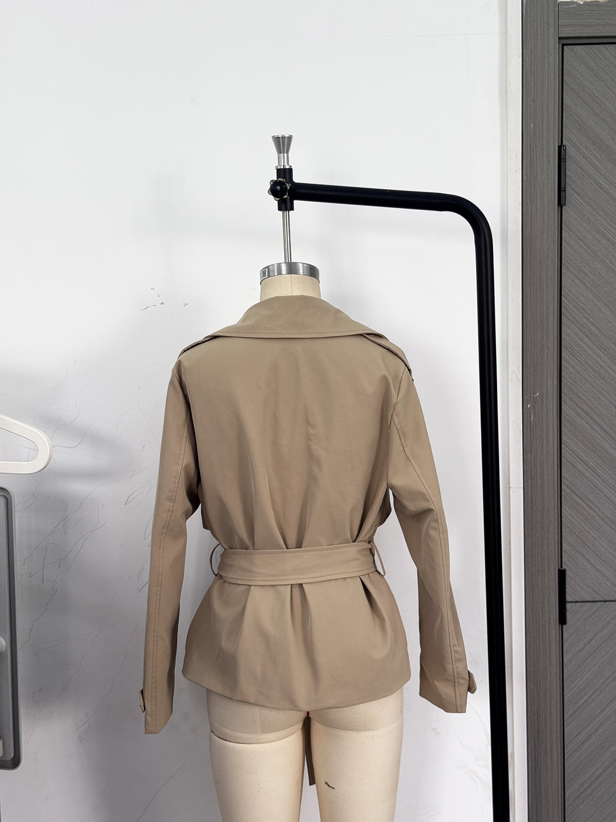 Cropped Double-Breasted Trench Jacket with Belt and Epaulettes in Khaki — back view on a dress form