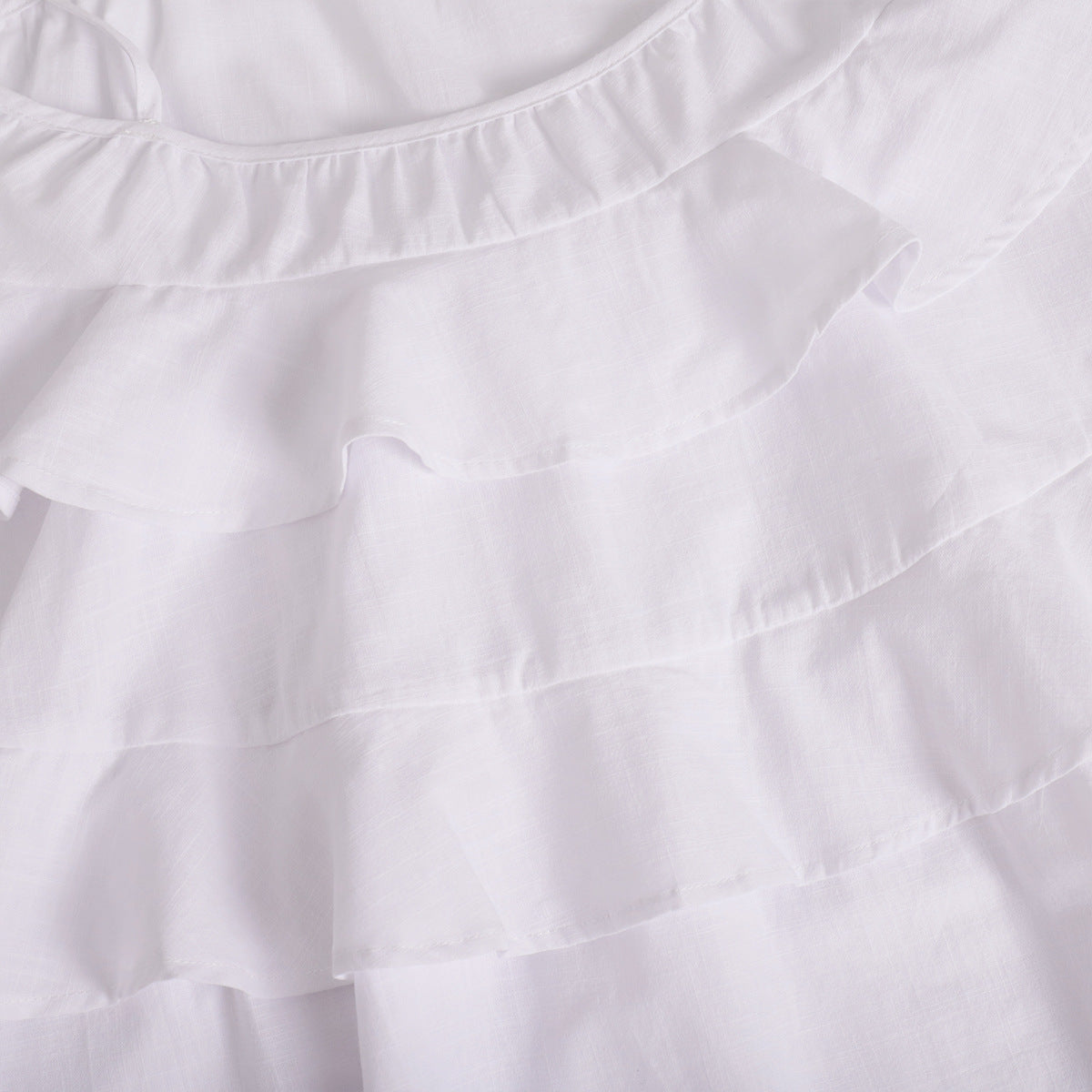 Tiered Ruffle Tie-Strap Mini Dress in White — close-up of the tiered ruffles