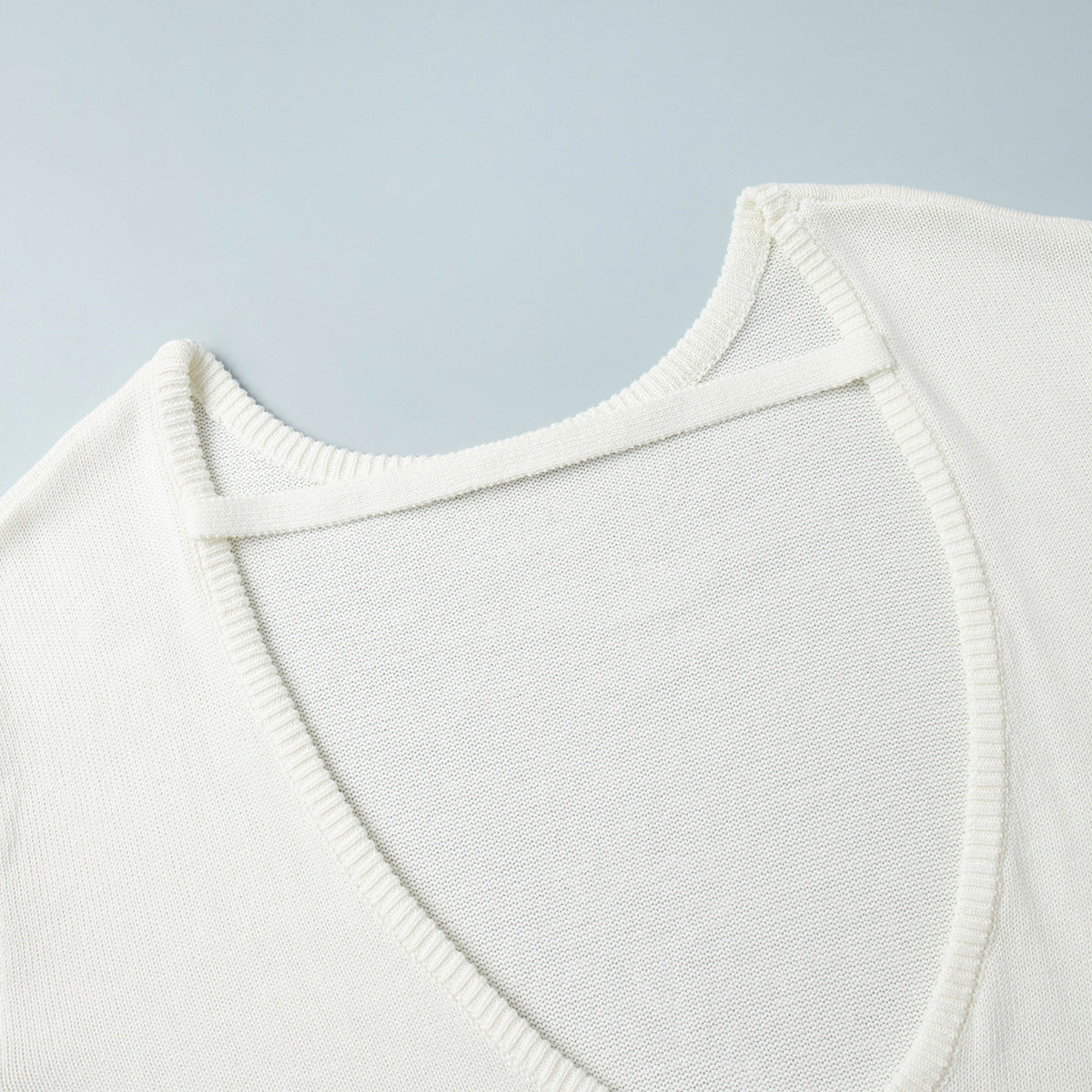 Oversized Open-Back Cotton Knit Sweater in Cream — close-up of the open back and strap