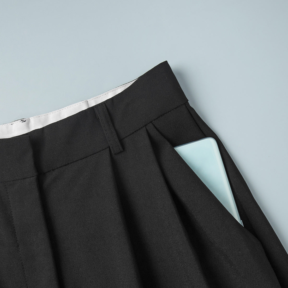 Pleated Wide-Leg Trousers in Black — close-up of side pocket