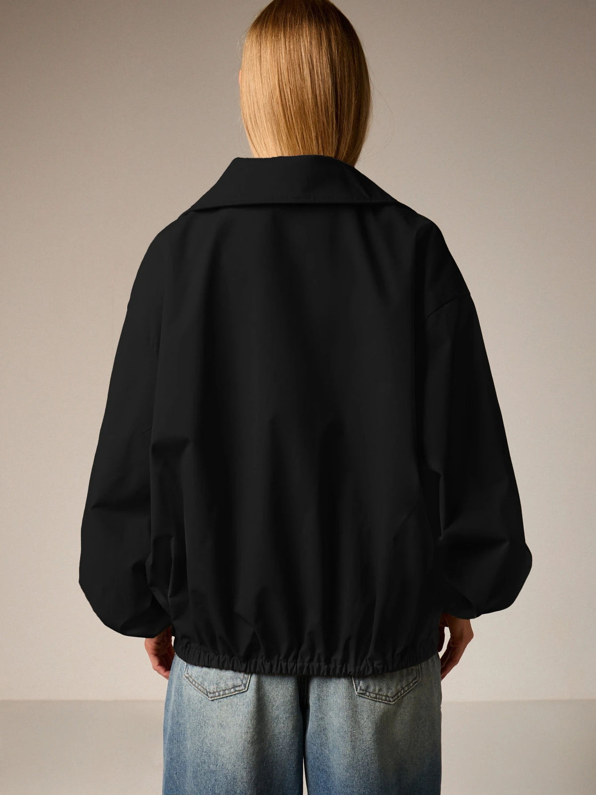 Oversized Half-Zip Funnel-Neck Windbreaker Jacket in Black — back view on model