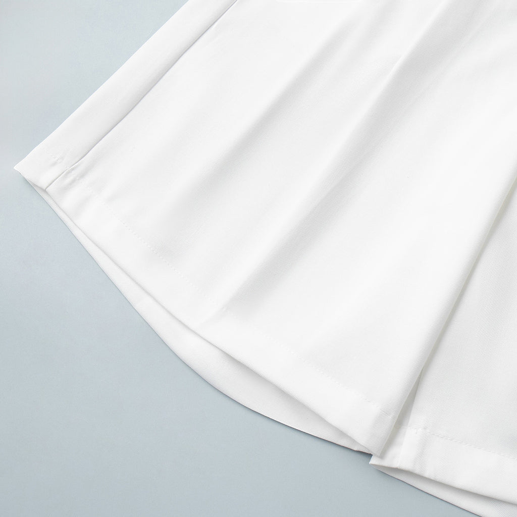 High-Waist Pleated Bermuda Shorts in White — close-up of hem