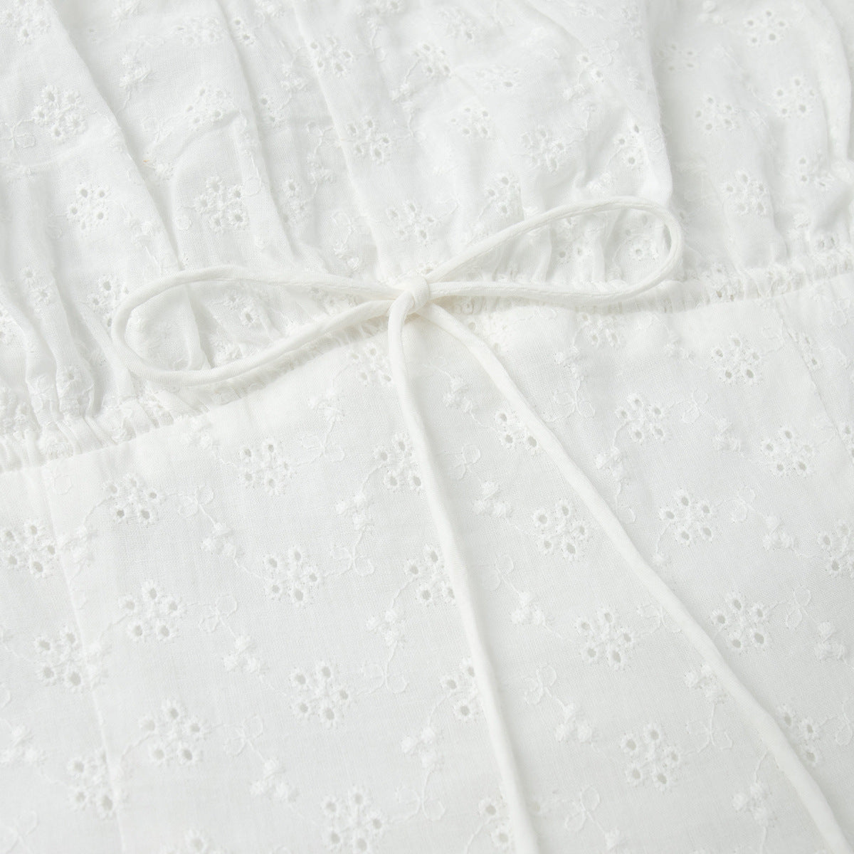 Eyelet Cotton Off-Shoulder Midi Dress in Ivory Eyelet — close-up of front lace-up tie