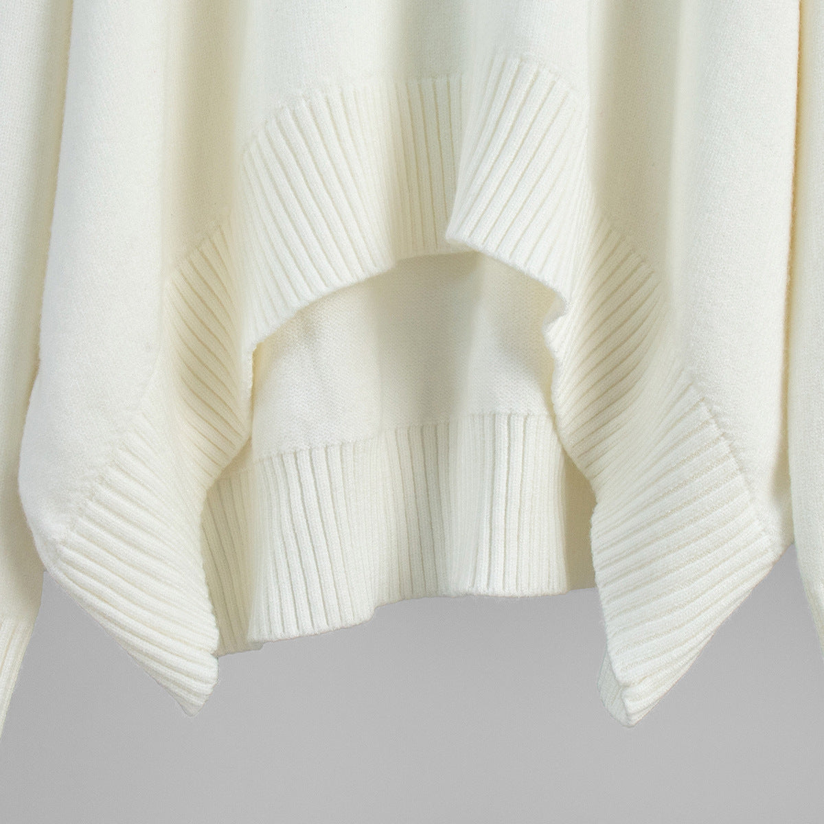 Oversized Turtleneck Sweater & Knit Maxi Skirt Set in Ivory — close-up of the ribbed hem with side slit