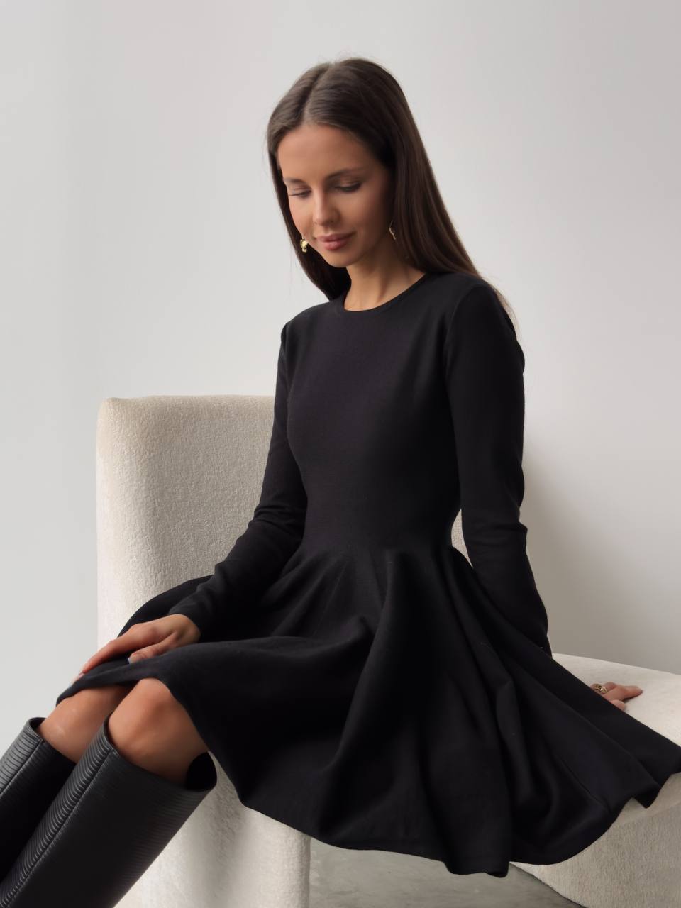 Fitted Knit Skater Mini Dress with Long Sleeves in Black — seated view on model