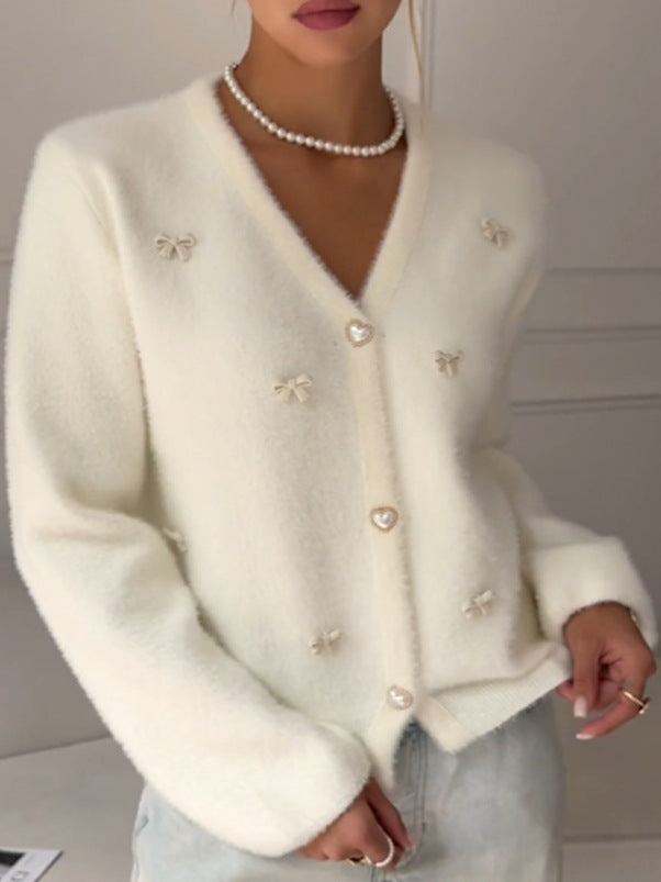 Soft Bow-Embellished V-Neck Cardigan in Ivory — close-up of the bows and buttons