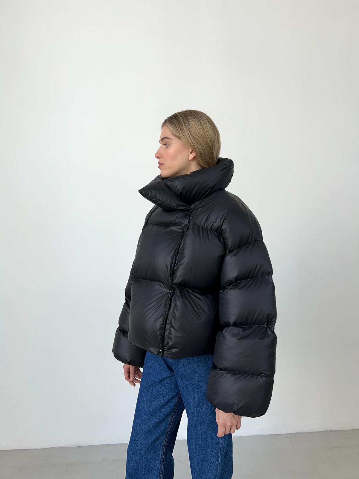 Cropped Hooded Puffer Jacket with Drawstring Hem in Black — side view on model