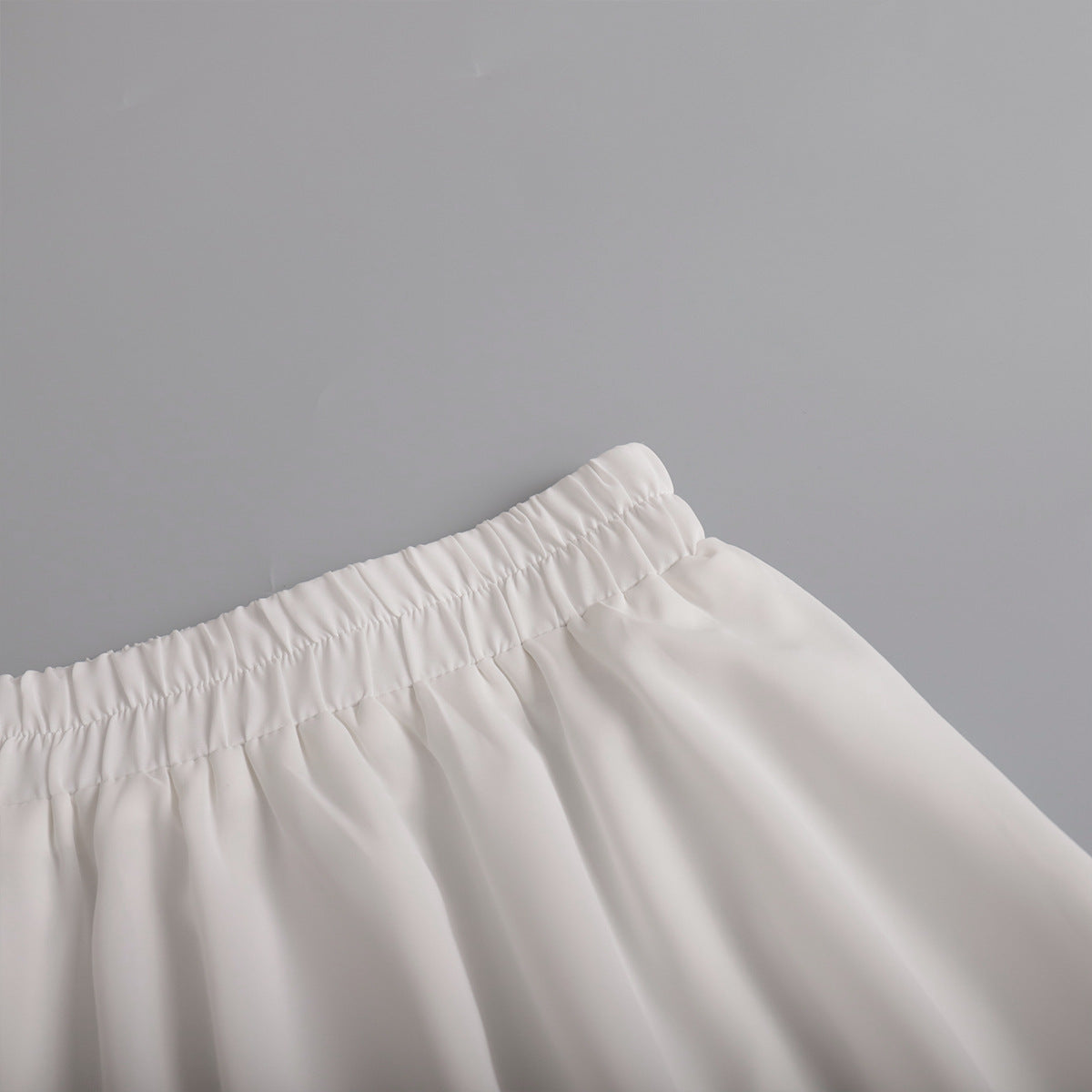 Pleated Bubble Mini Skirt in White — close-up of hem
