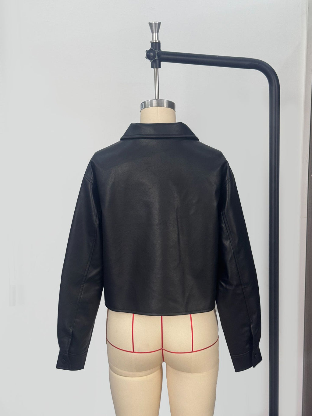 Cropped Faux Leather Shirt Jacket with Patch Pockets in Black — back view on a dress form